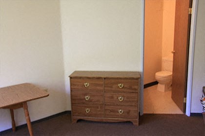 a dresser in a room with a toilet and a table