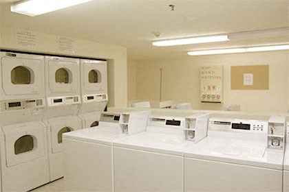 a group of washers and dryers in a laundry room