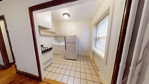 A kitchen with white cabinets and a black dishwasher.