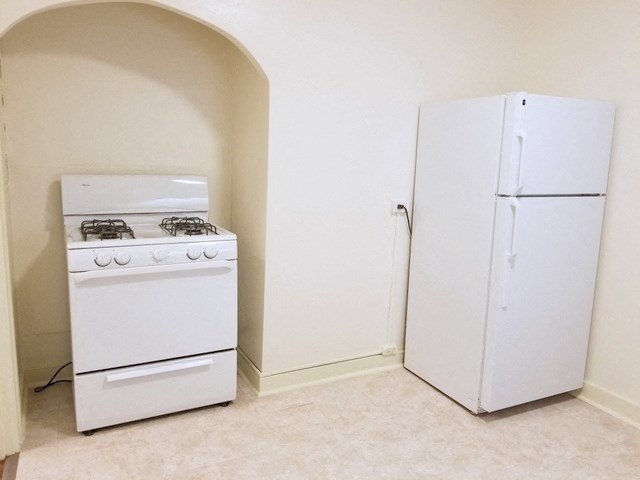 an empty kitchen with a stove and a refrigerator