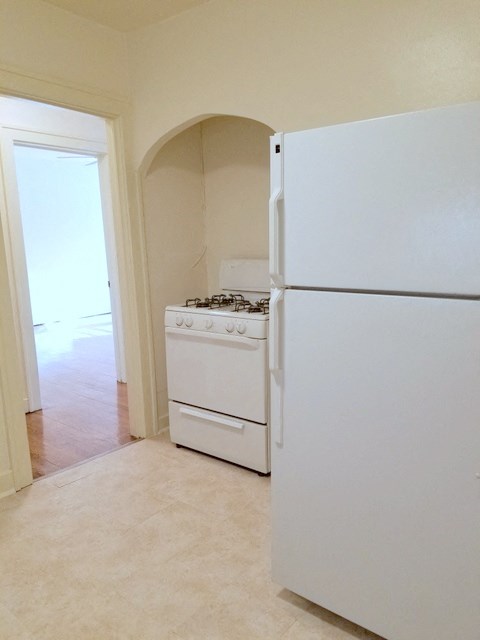 an empty kitchen with a stove and a refrigerator