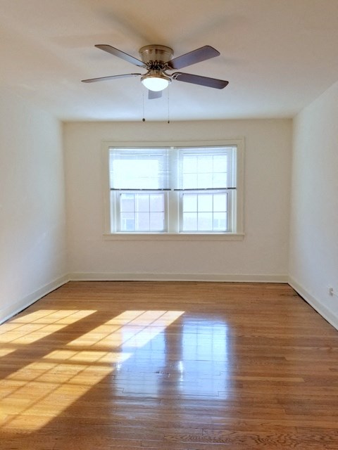 an empty room with a ceiling fan and a window
