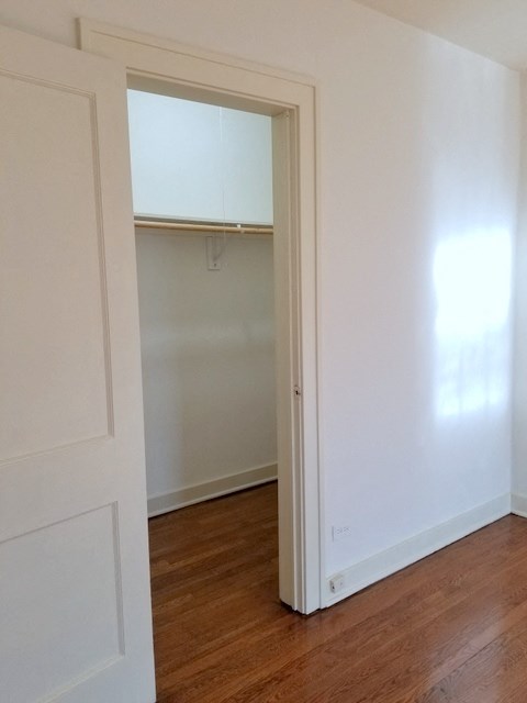 an open closet door in a room with a wood floor