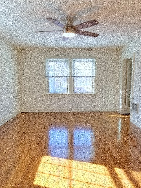 an empty living room with a ceiling fan