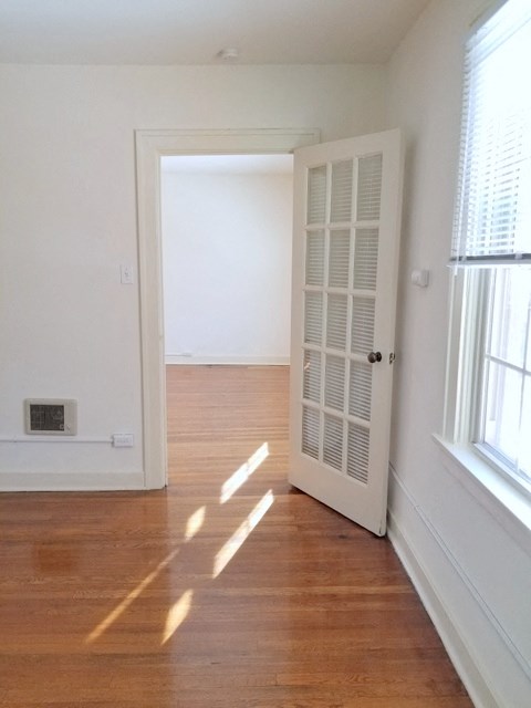 an empty room with an open door and a wood floor