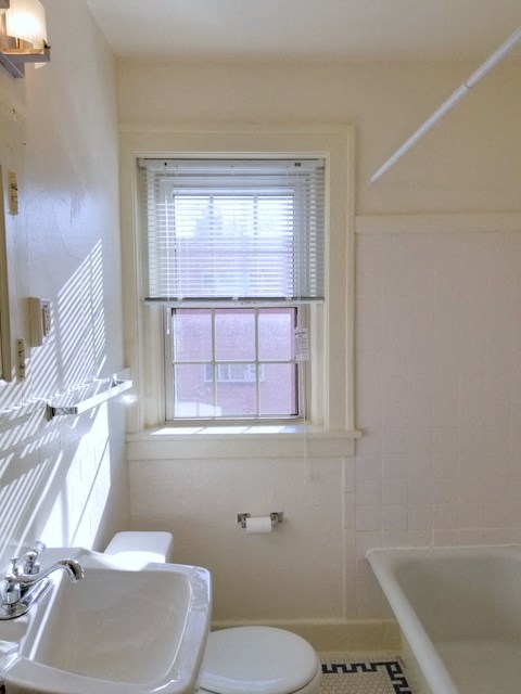 a bathroom with a toilet and a sink and a window