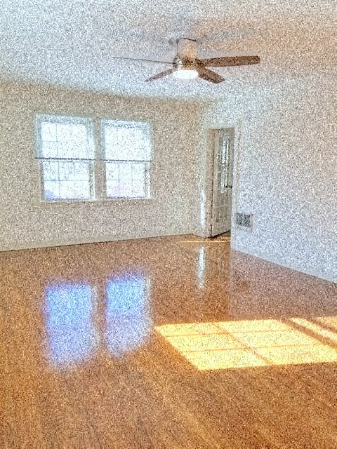 an empty living room with a ceiling fan