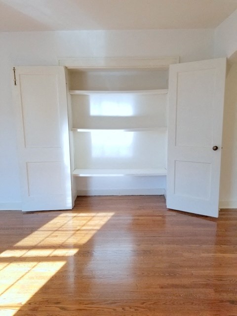 an empty room with white walls and wooden floors