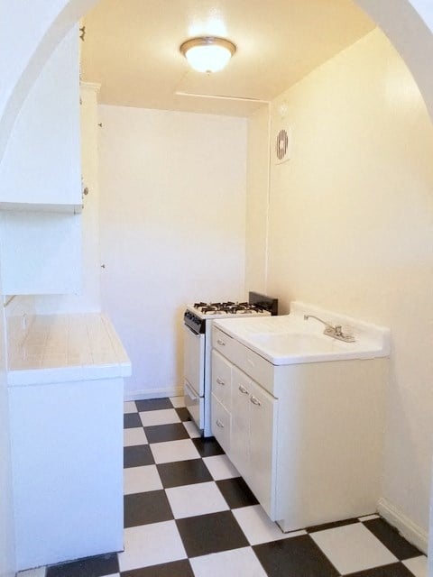 a kitchen with a checkered floor and a stove and sink