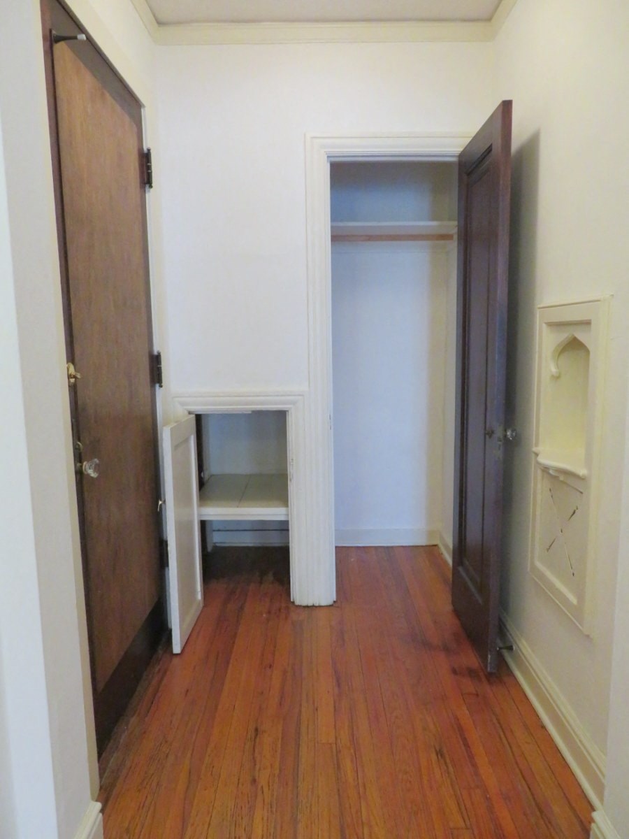 a room with wooden floors and a closet with a door open