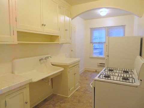a kitchen with a stove and sink and a refrigerator
