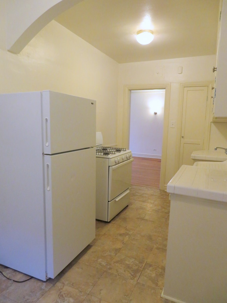 a kitchen with a refrigerator and a stove and a sink