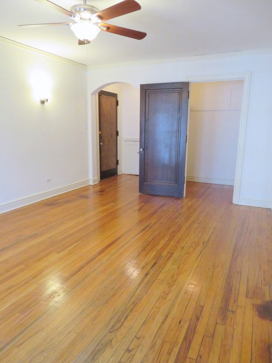 an empty living room with a wooden floor and a wardrobe