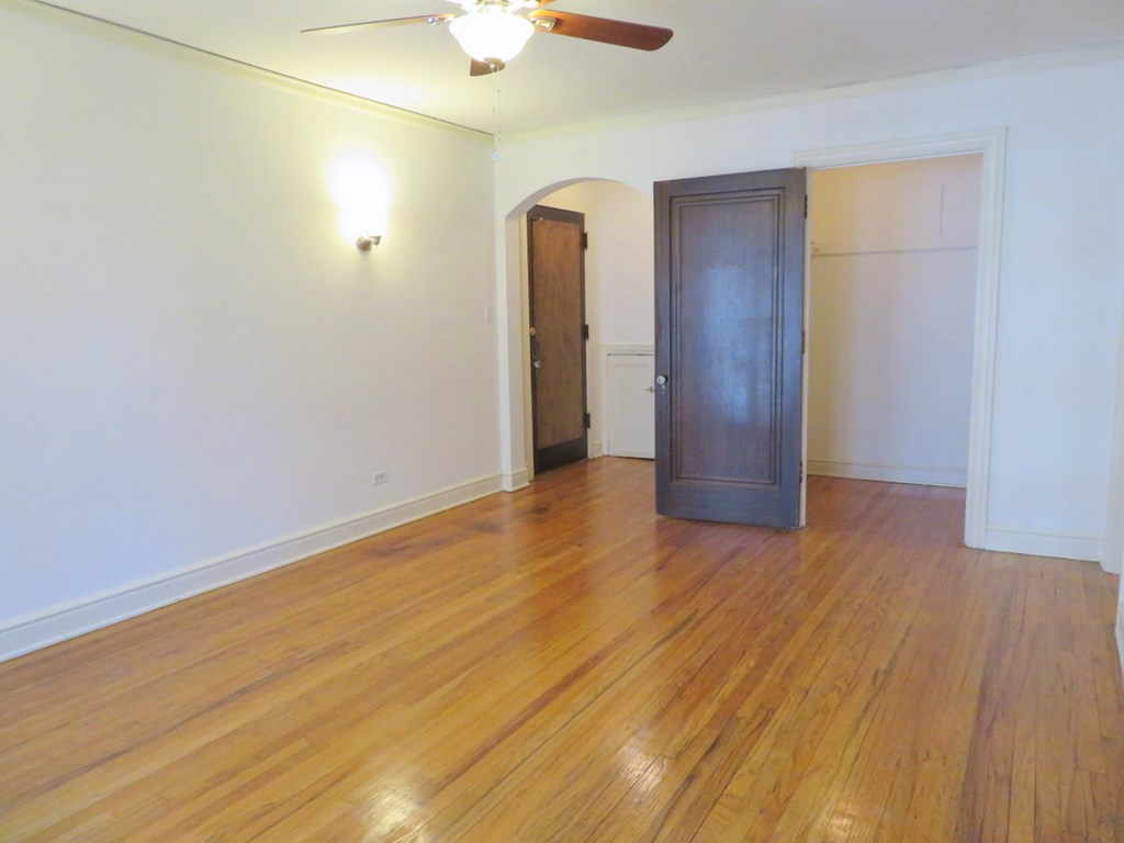 a empty living room with a wooden floor and a closet