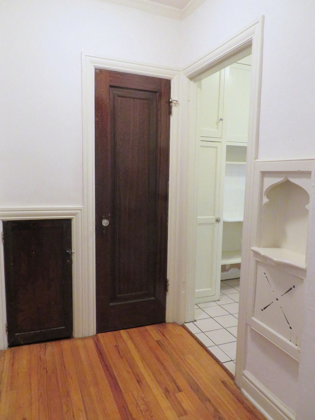 a room with a wooden floor and a door to a closet
