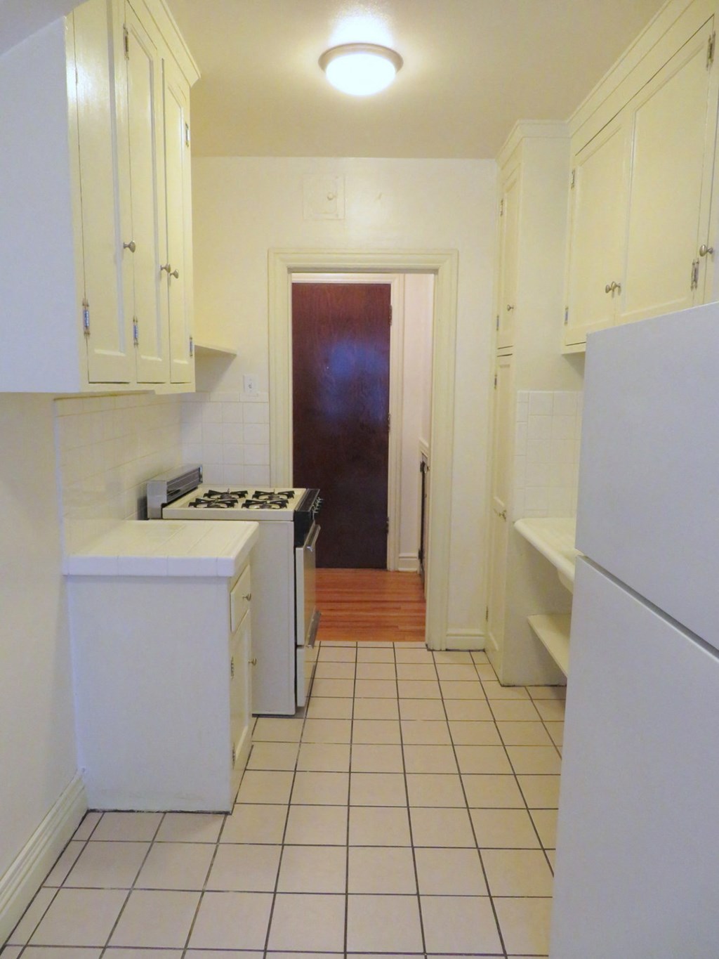 a kitchen with white cabinets and a stove and a refrigerator