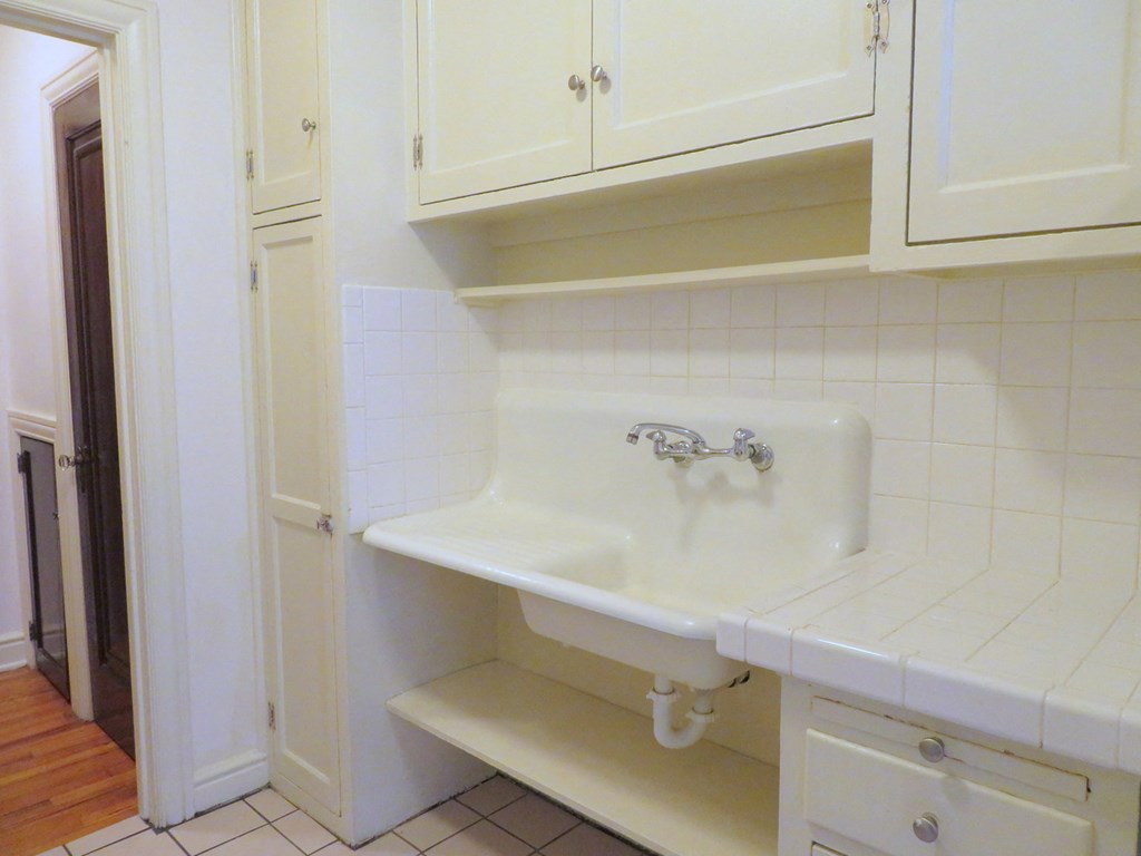 a sink in a kitchen with white cabinets