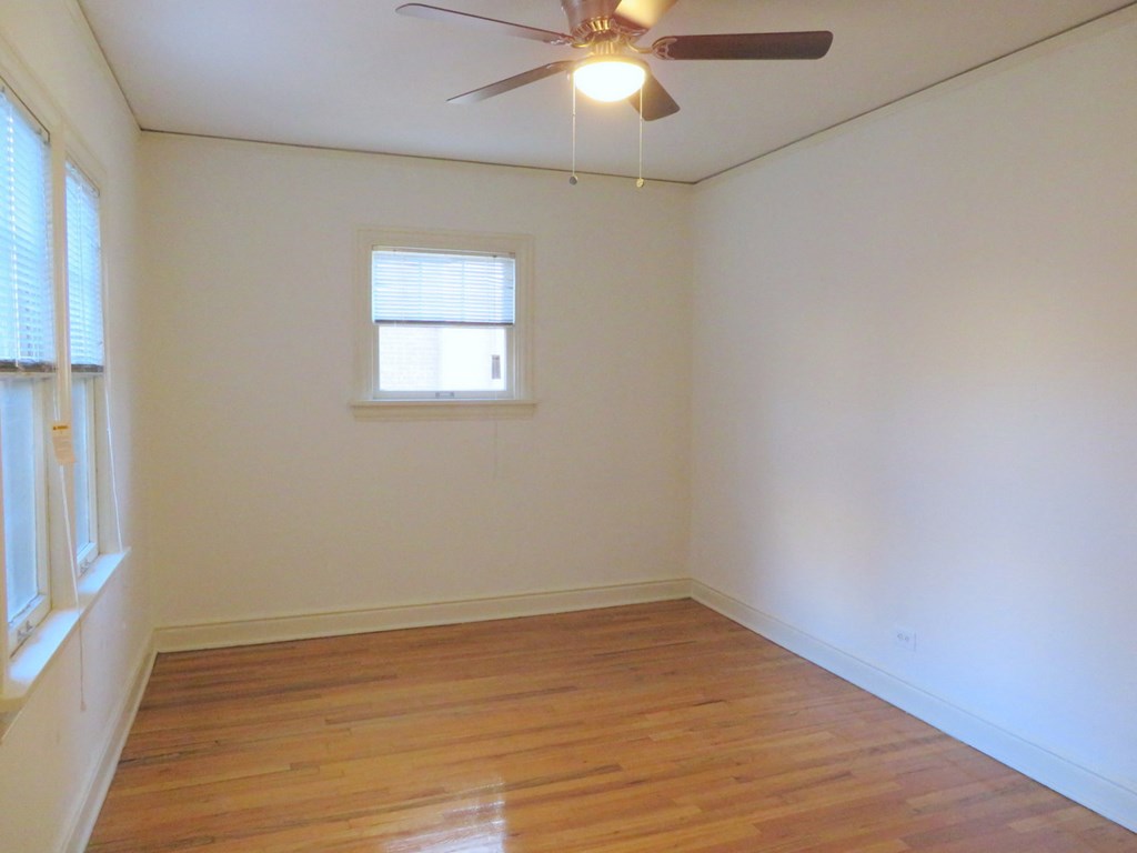 an empty room with a ceiling fan and a window