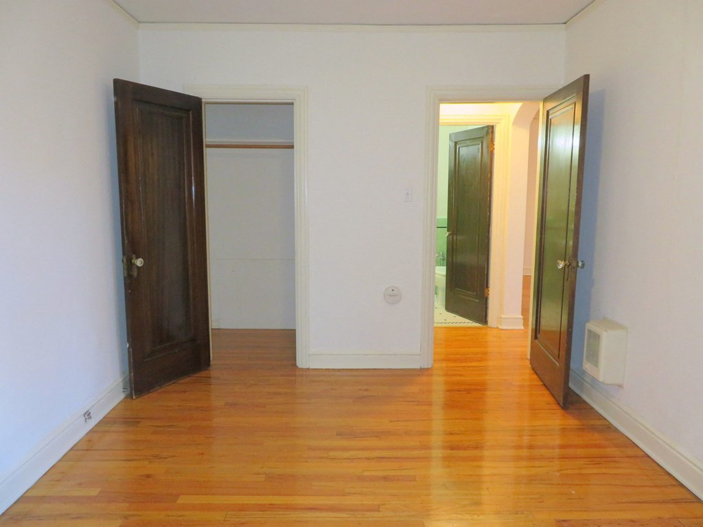 a empty living room with wood floors and a door