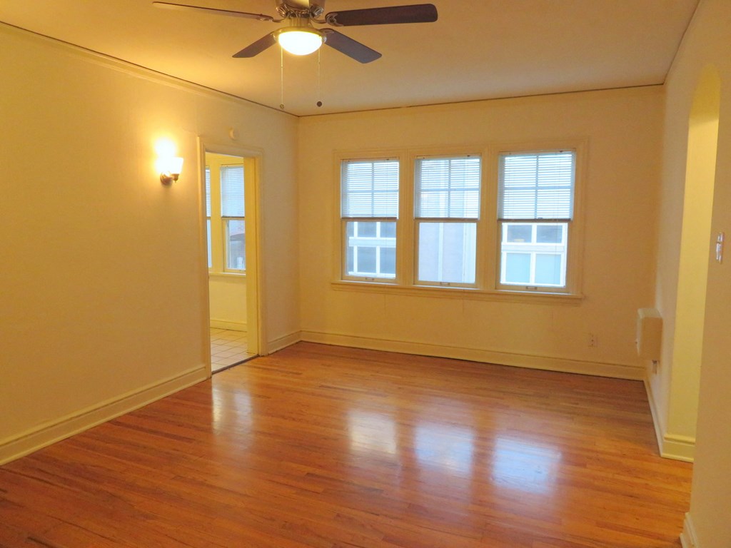 the living room of an empty house with a ceiling fan