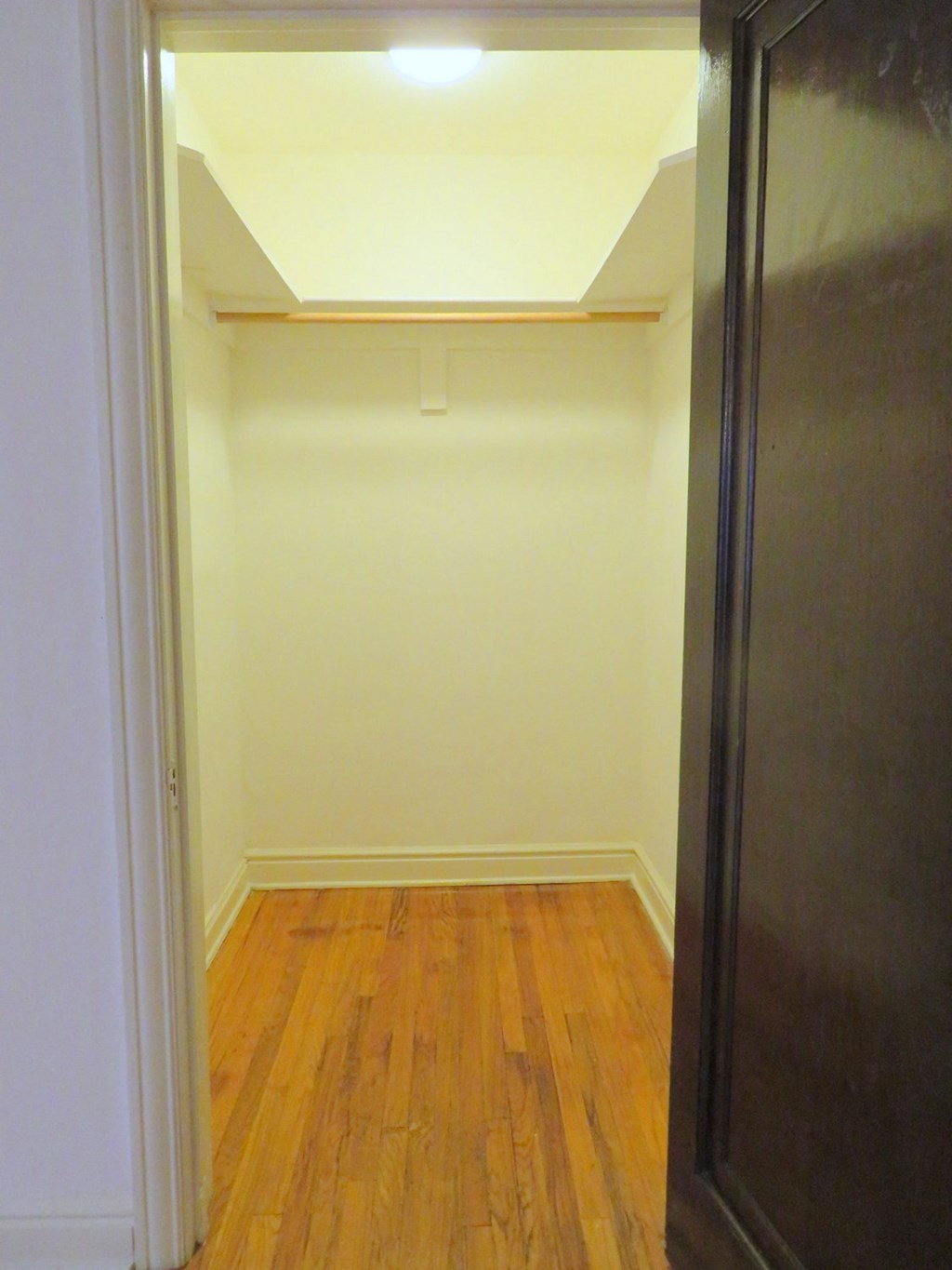 an empty room with a wooden floor and a door