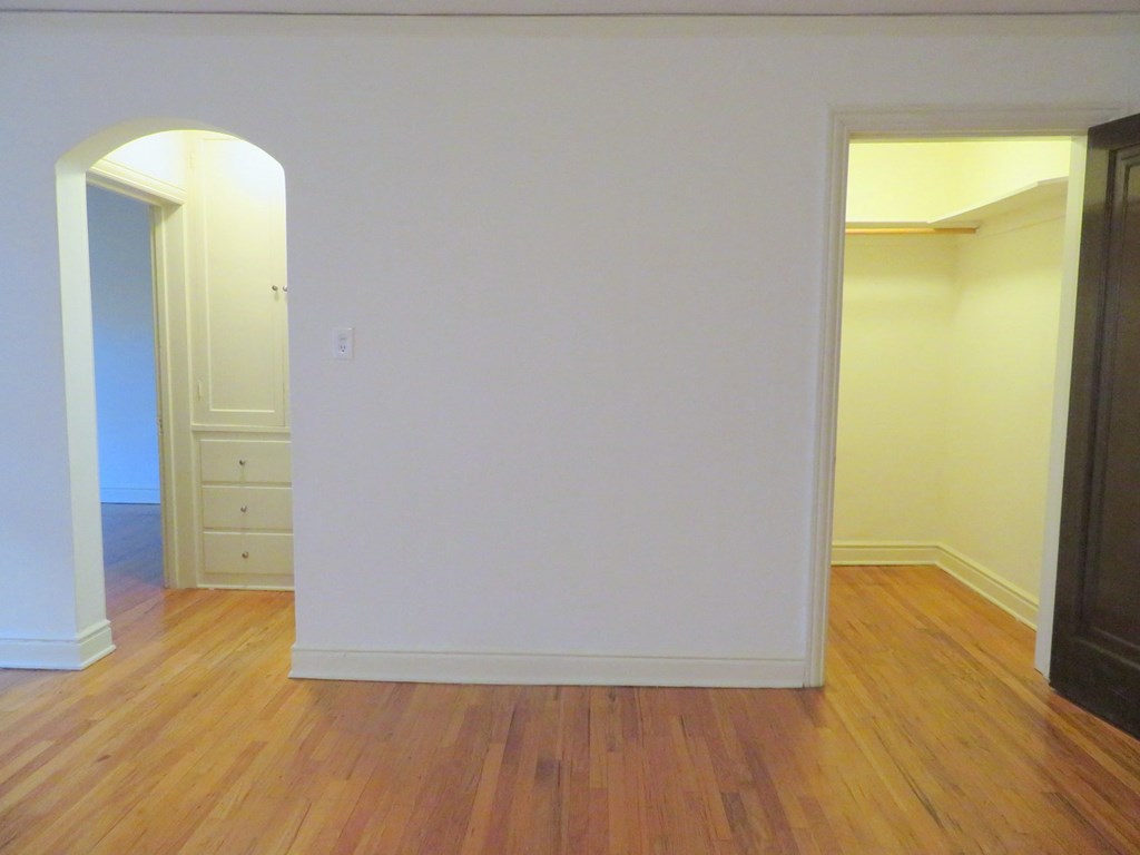 an empty living room with white walls and wooden floors