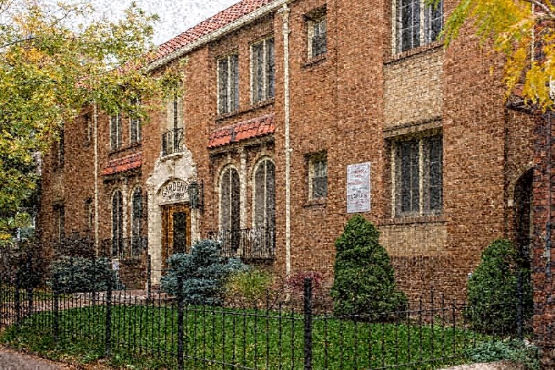 a large brick building with a fence in front of it