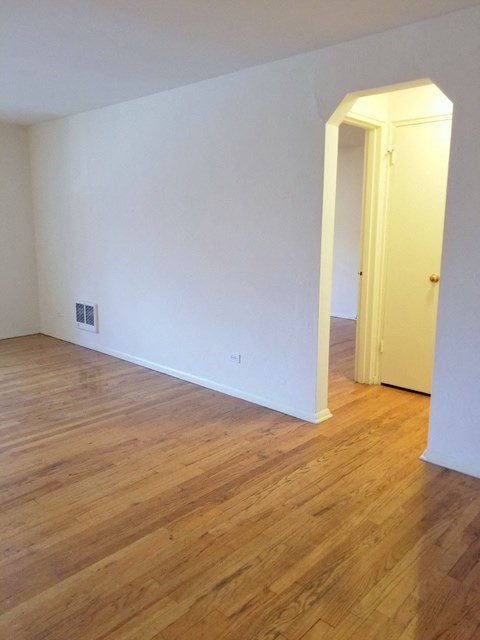 an empty living room with white walls and wooden floors