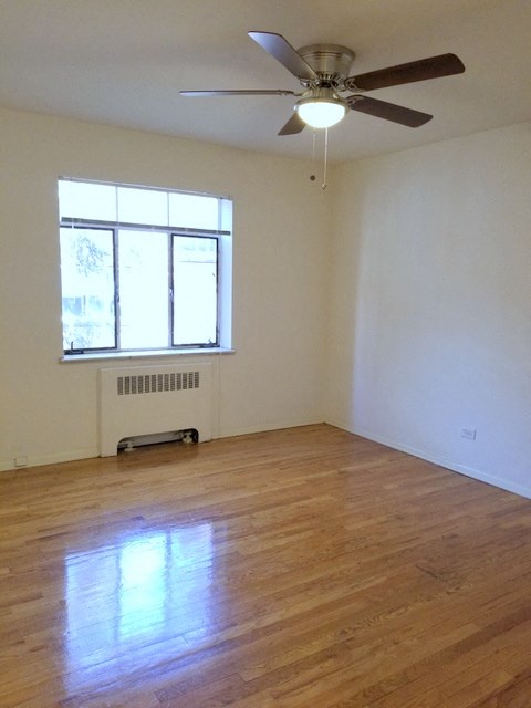 an empty room with a ceiling fan and a window