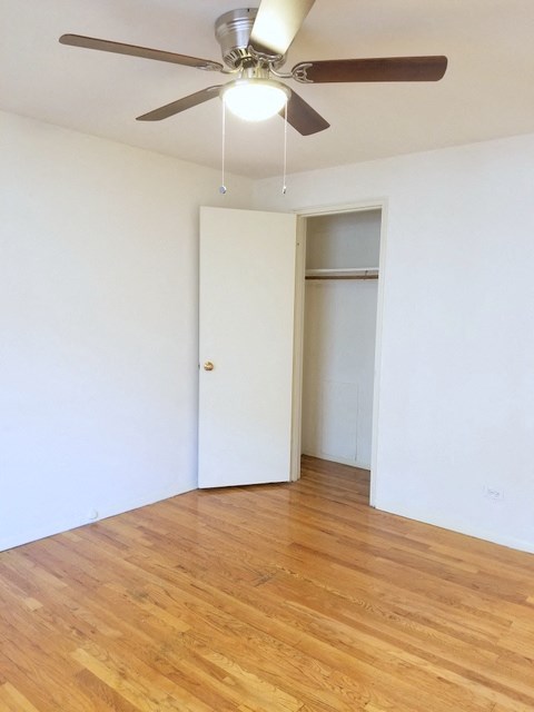 an empty room with a ceiling fan and a closet