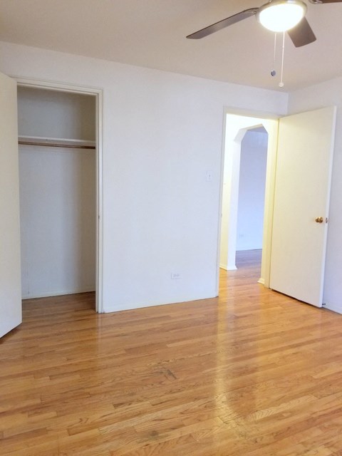 an empty living room with wood floors and a closet