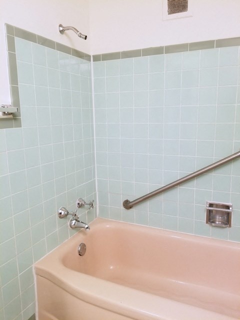 a bath tub in a bathroom with blue tiles