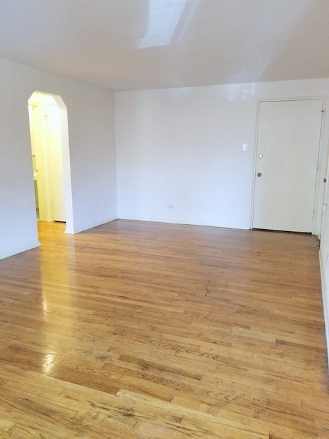 an empty living room with white walls and wooden floors