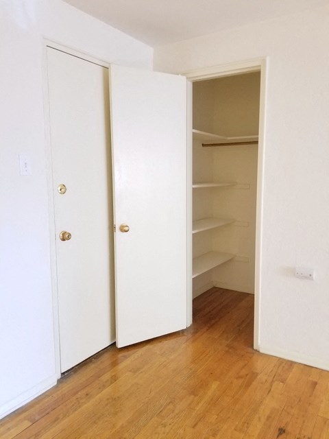 an empty closet in a room with a wood floor