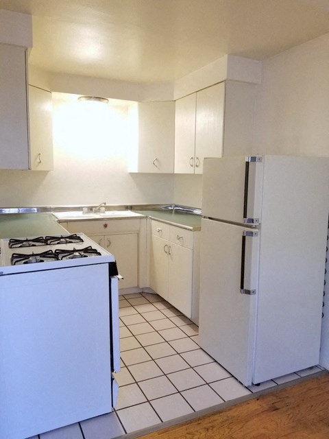 an empty kitchen with a stove and a refrigerator