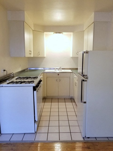 an empty kitchen with a stove and a refrigerator