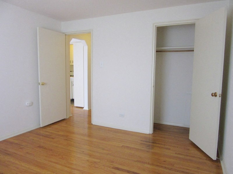 an empty room with white walls and a wood floor
