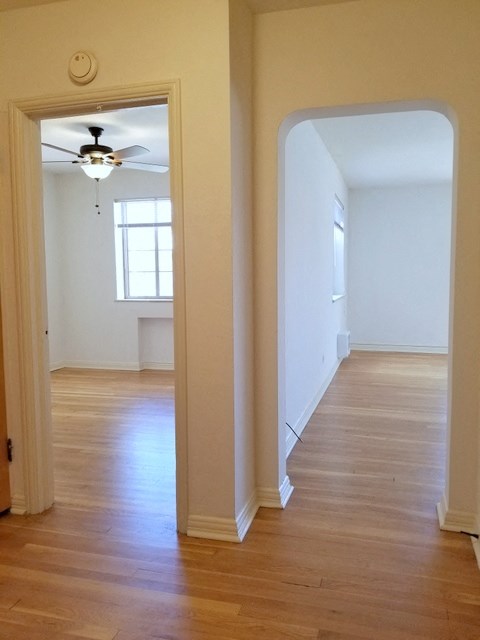 an empty room with a ceiling fan and wood floors