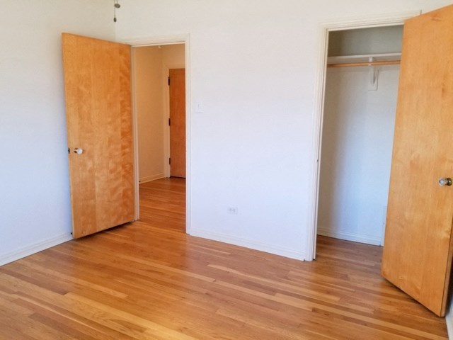 an empty room with wooden floors and a closet