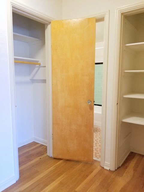 a closet with shelves and a wooden door