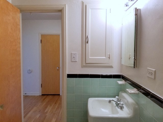 a bathroom with a sink and a mirror and a door