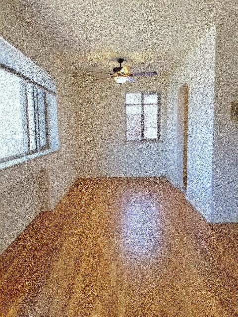 an empty room with a ceiling fan and a window