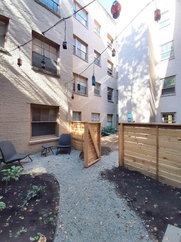 the back yard of an apartment building with a wooden fence