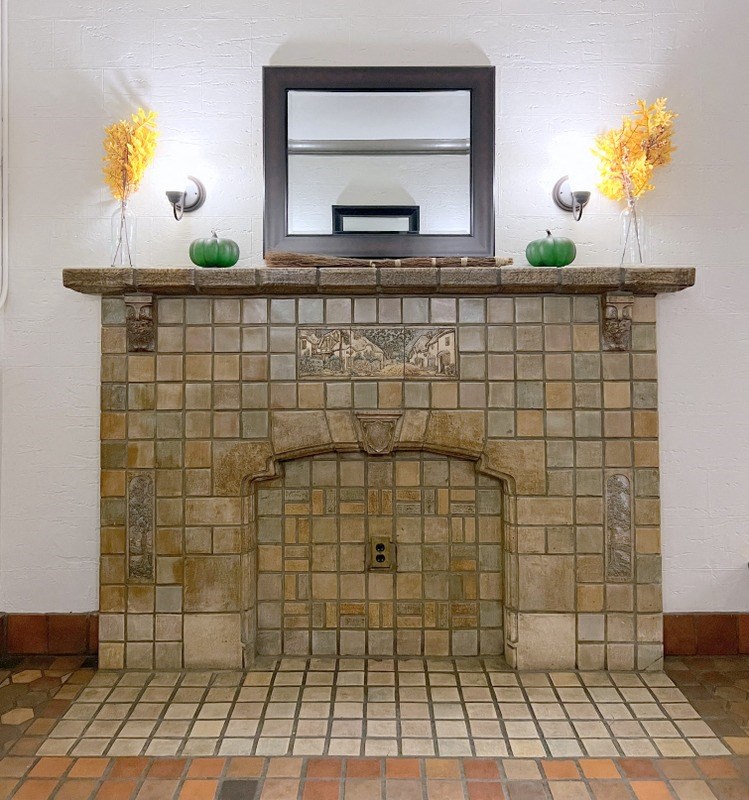 a stone fireplace with a mirror above it