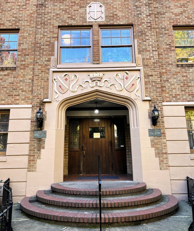 the front door of a brick building with steps in front of it