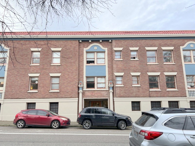 a brick building with cars parked in front of it