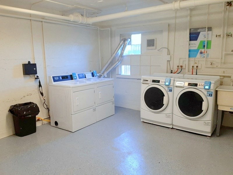 an empty laundry room with two washing machines and a sink