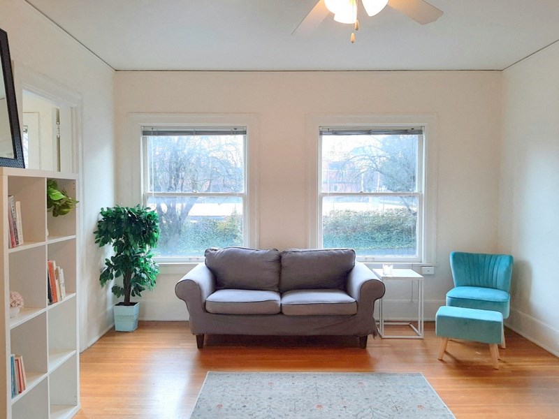 a living room with a couch and two windows