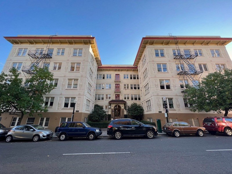 a group of cars parked in front of an apartment building