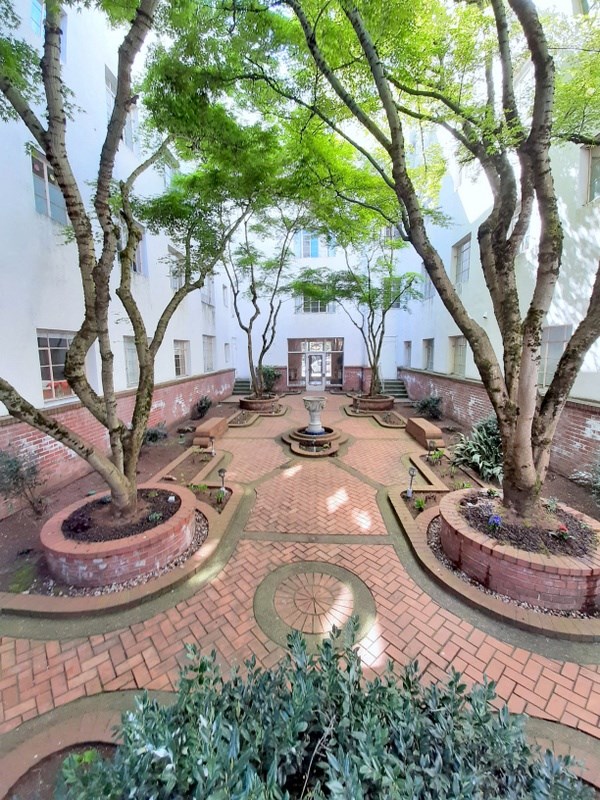 a courtyard with trees and a fountain in the center of a building